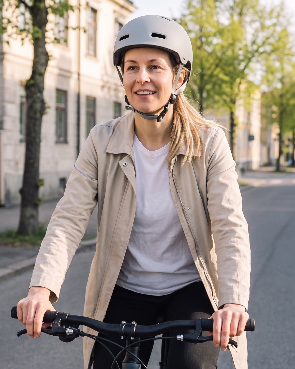Kvinna cyklar genom stan en ljus morgon